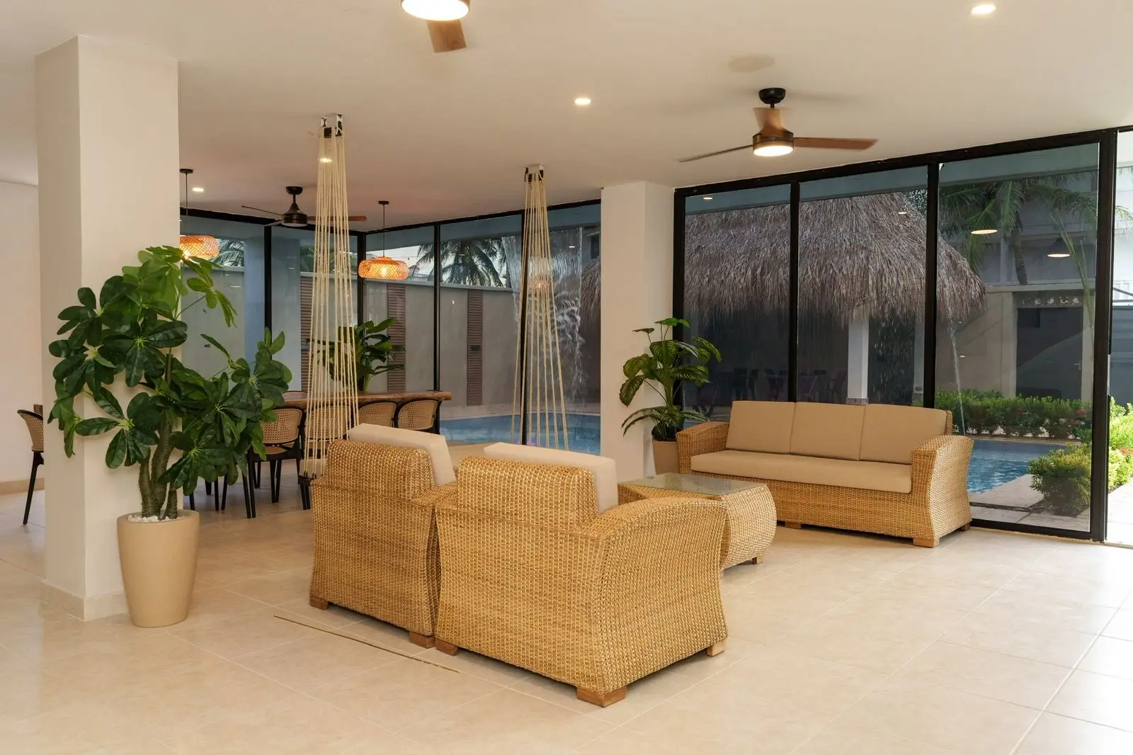 Sala social con muebles de ratán, escalera y doble altura
