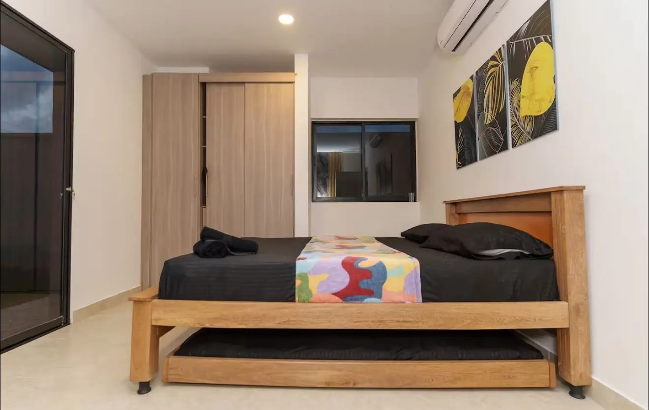 Habitación con cama doble en madera y aire acondicionado